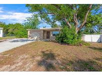 Charming single-story home featuring mature trees, well-maintained front lawn, and inviting curb appeal at 6104 Cork Ct, New Port Richey, FL 34653