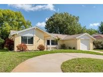 Charming one-story home with a brick facade, well-maintained lawn, and a curved driveway at 8505 Lincolnshire Dr, Hudson, FL 34667