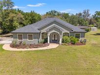 Charming single-story home featuring manicured landscaping, mature trees, and a welcoming entrance with columns at 10645 Fawn Dr, New Port Richey, FL 34654