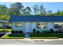 Charming single-story home featuring a well-manicured lawn and blue metal roofing at 11814 Carissa Ln, New Port Richey, FL 34654