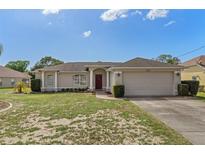 Charming single-story home with a well-manicured lawn, classic architectural details, and an attached two-car garage at 3345 Carmen Ave, Spring Hill, FL 34609
