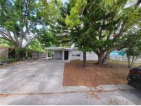 Charming single-story home with mature trees and covered parking, creating a welcoming curb appeal at 4118 Flamingo Dr, New Port Richey, FL 34652