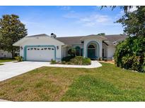 Charming single-story home with a well-manicured lawn, two-car garage, and a lovely blue trim at 473 Tournament Dr, Spring Hill, FL 34608