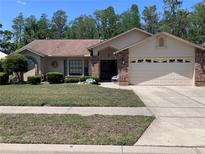 Charming single-story home with a manicured front yard, well-maintained lawn, and a two car garage at 5045 Musselshell Dr, New Port Richey, FL 34655