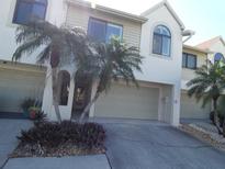 Charming townhome with attached garage and well-maintained landscaping featuring lovely palm trees in a desirable community at 545 Walden Ct, Dunedin, FL 34698