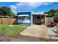 Charming single-story home with blue and white trim, a small front yard, and a motorcycle parked outside at 6507 Ginny Dr, Port Richey, FL 34668