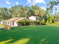 Expansive yard showcases this two-story home surrounded by mature trees and lush tropical landscaping at 7101 N 18Th St, Tampa, FL 33610