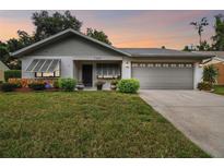 Charming home with a well-maintained lawn and an attached two-car garage at 7427 Baltusrol Dr, New Port Richey, FL 34654