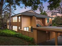 Inviting multi-level condo featuring wood siding, a covered parking area, and well-maintained landscaping at 1208 Cypress Pond Rd, Palm Harbor, FL 34683