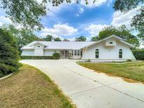 Stunning home exterior with a long driveway, lush landscaping, and a unique architectural style at 1276 Meredith Dr, Spring Hill, FL 34608