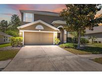Charming two-story home with a well-manicured lawn, mature landscaping, and a two-car garage at 18331 Waydale Loop, Hudson, FL 34667
