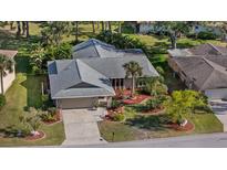 Inviting single Gathering home with manicured lawn, mature landscaping, and gray roof at 4504 Dewey Dr, New Port Richey, FL 34652