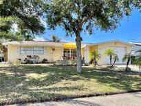 Charming single-story home with a well-manicured lawn and mature trees providing ample shade at 5128 Perennial Dr, Holiday, FL 34690