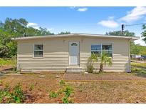 Charming single-story home featuring a crisp white front door and a well-maintained, neutral-toned exterior at 6418 E 23Rd Ave, Tampa, FL 33619
