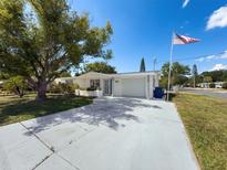 Charming single-story home boasts a brick facade, spacious driveway, and a well-manicured lawn at 6431 Gainsboro Dr, Port Richey, FL 34668