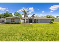 Charming single-story home featuring a well-manicured lawn, double-door entryway, and tasteful landscaping at 7466 Jonquil Pl, Weeki Wachee, FL 34607