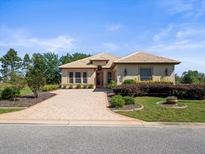 Charming home with brick driveway, landscaped garden, and inviting entryway offers great curb appeal at 9159 Trevino Dr, Weeki Wachee, FL 34613