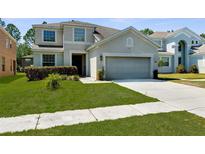 Charming two-story home featuring a well-maintained lawn and a two-car garage at 951 Nodding Shade Dr, Brooksville, FL 34604