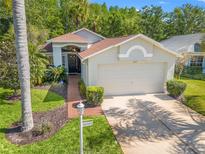 Charming single-story home with a two-car garage, well-manicured lawn, and mature landscaping at 1013 Sweet Jasmine Dr, Trinity, FL 34655