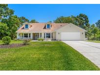 Charming one-story home with a two-car garage, a well-manicured lawn, and inviting curb appeal at 10540 Noddy Tern Rd, Weeki Wachee, FL 34613