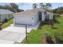 Charming single-story home featuring well-manicured lawn, two-car garage, and a welcoming front entrance at 11732 Wheatfield Loop, Hudson, FL 34667