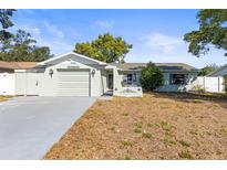 Charming single-story home featuring an attached garage and well-maintained front yard at 12065 Shadow Ridge Blvd, Hudson, FL 34669