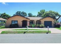 Charming single story home featuring an arched entryway and an attached garage at 13111 Sheridan Dr, Hudson, FL 34667
