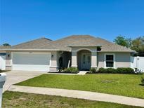 Charming single-story home with well-manicured lawn, neutral paint, and attached two car garage at 15585 Rene Ct, Brooksville, FL 34604