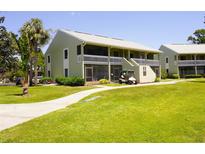 Two-story building with green lawn, sidewalk, and palm trees on a bright, sunny day at 1881 Mazo Mnr # I-6, Lutz, FL 33558