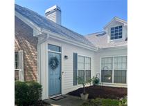 Charming home exterior showcasing a quaint blue front door with wreath and well-maintained landscaping at 2729 Penzance St, Palm Harbor, FL 34684