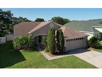 Charming single-story home featuring a two-car garage, well-manicured lawn, and mature landscaping at 3054 Oakbrook Cir, Clearwater, FL 33759