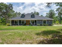 Charming single-story home featuring a covered front porch and well-maintained lawn and landscaped front yard at 3355 La Vista St, Brooksville, FL 34604