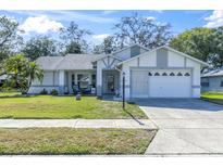Charming single-story home with a well-maintained lawn, landscaping, and an attached two-car garage at 4837 Prince George Cir, New Port Richey, FL 34655