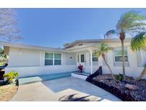 Charming single-story home featuring a well-manicured yard with lush landscaping and palm trees at 5404 Quist Dr, Port Richey, FL 34668