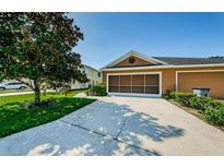 Charming home featuring a two-car garage, complemented by a driveway and front yard at 8604 Corinthian Way, New Port Richey, FL 34654