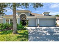 Charming single-story home featuring a well-manicured lawn, mature trees and a two car garage at 8635 Creedmoor Ln, New Port Richey, FL 34654