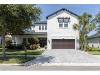 Beautiful two-story home with landscaped front yard, brick driveway, and a two-car garage at 8945 Bella Vita Cir, Land O Lakes, FL 34637