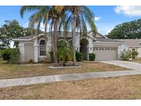Charming home featuring a two-car garage, mature landscaping, and a well-manicured lawn at 9104 Water Hazard Dr, Hudson, FL 34667
