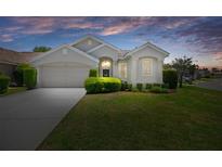 Charming single-story home with a well-manicured lawn and inviting curb appeal set against a colorful sunset sky at 9400 New Orleans Dr, Weeki Wachee, FL 34613