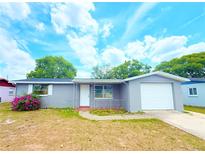 Charming single-story home with gray exterior, attached garage, and well-maintained front yard at 9850 Richwood Ln, Port Richey, FL 34668
