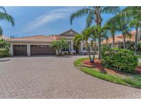 Charming home with a three car garage, brick paved driveway, and lush tropical landscaping at 1033 Tuscany Dr, Trinity, FL 34655