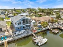 Waterfront two-story home with a boat lift, dock, and screened-in porch overlooking the canal at 15535 Allmand Dr, Hudson, FL 34667
