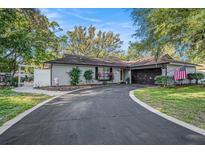 Charming single-story home featuring a well-maintained front yard and a long driveway leading to an attached garage at 2254 Coachman Rd, Spring Hill, FL 34608