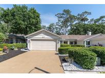 Well-maintained one-story home with manicured landscaping and a two-car garage on a sunny day at 3047 Bolt Dr, Palm Harbor, FL 34685