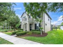 Charming two-story home featuring a balcony, black shutters, and a well-manicured front yard with lush landscaping at 3057 Riders Pass, Odessa, FL 33556