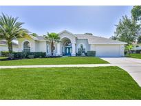 Charming single-story home with well-manicured lawn and lush landscaping at 4044 Chesterfield Dr, Spring Hill, FL 34609