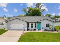 Charming single-story home features a well-manicured lawn and a bright teal front door at 4315 Oakland Dr, New Port Richey, FL 34653