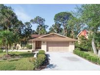Charming single-story home featuring a well-manicured lawn, mature trees, and a two-car garage at 4328 Marine Pkwy, New Port Richey, FL 34652
