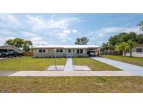 Charming single-story home featuring a well-maintained lawn and covered parking at 5031 Essex Ln, Spring Hill, FL 34606