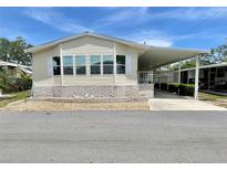 Well-maintained mobile home featuring a covered carport and manicured gravel landscaping at 585 Sky Harbor Dr # 219, Clearwater, FL 33759